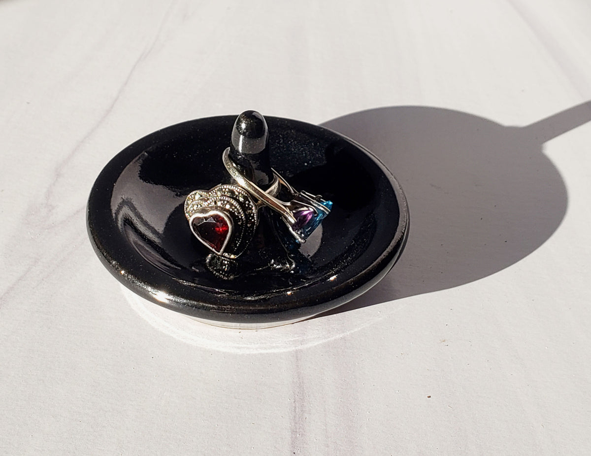 Black ring holder with silver rings on a white surface