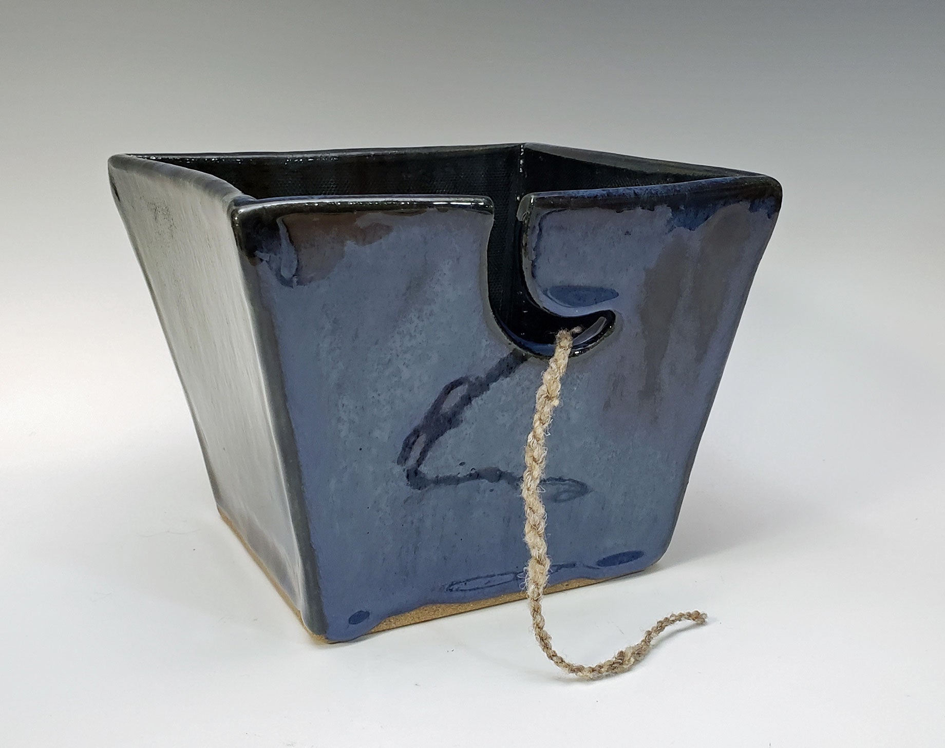 Dark blue stoneware yarn bowl on a white background