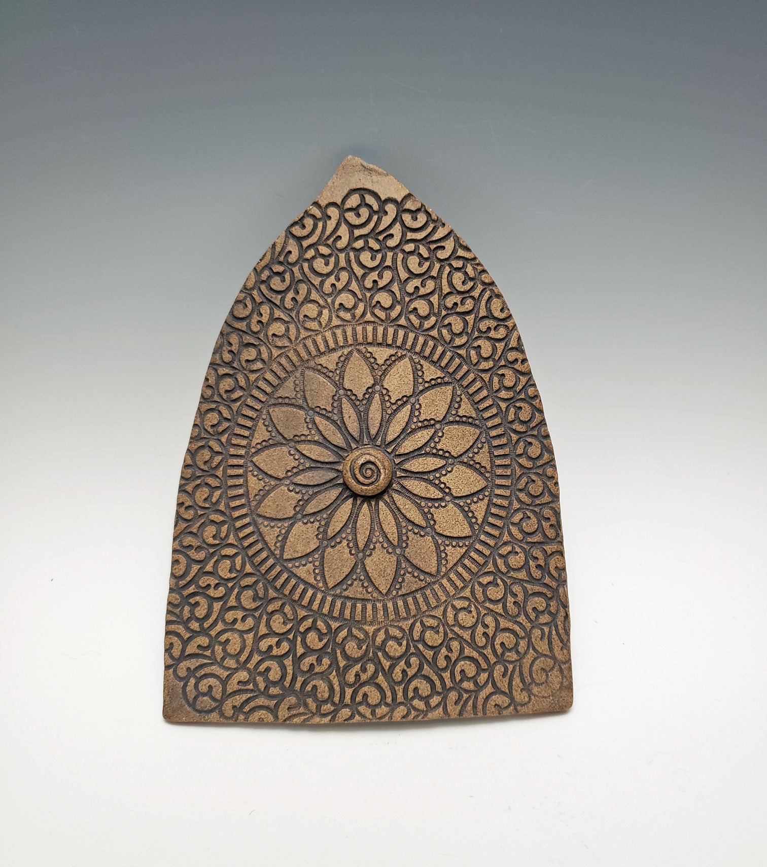 Stoneware fairy door with mandala design on a gray background