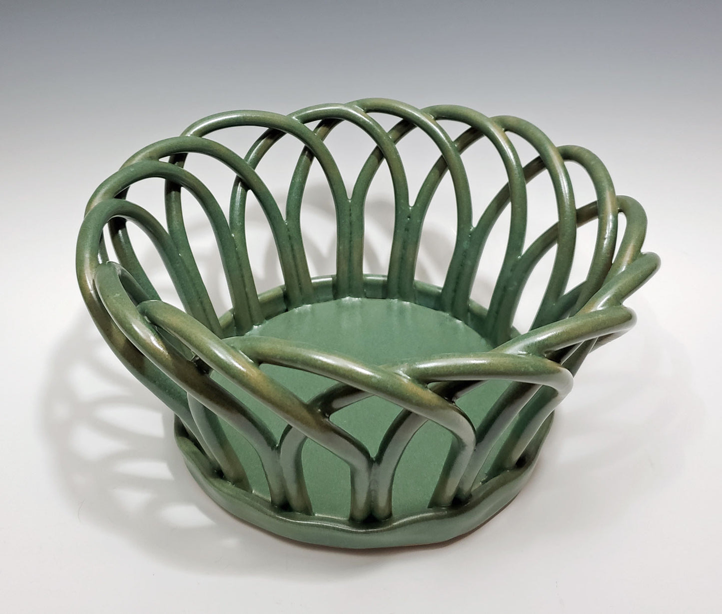 Green stoneware basket on a white background