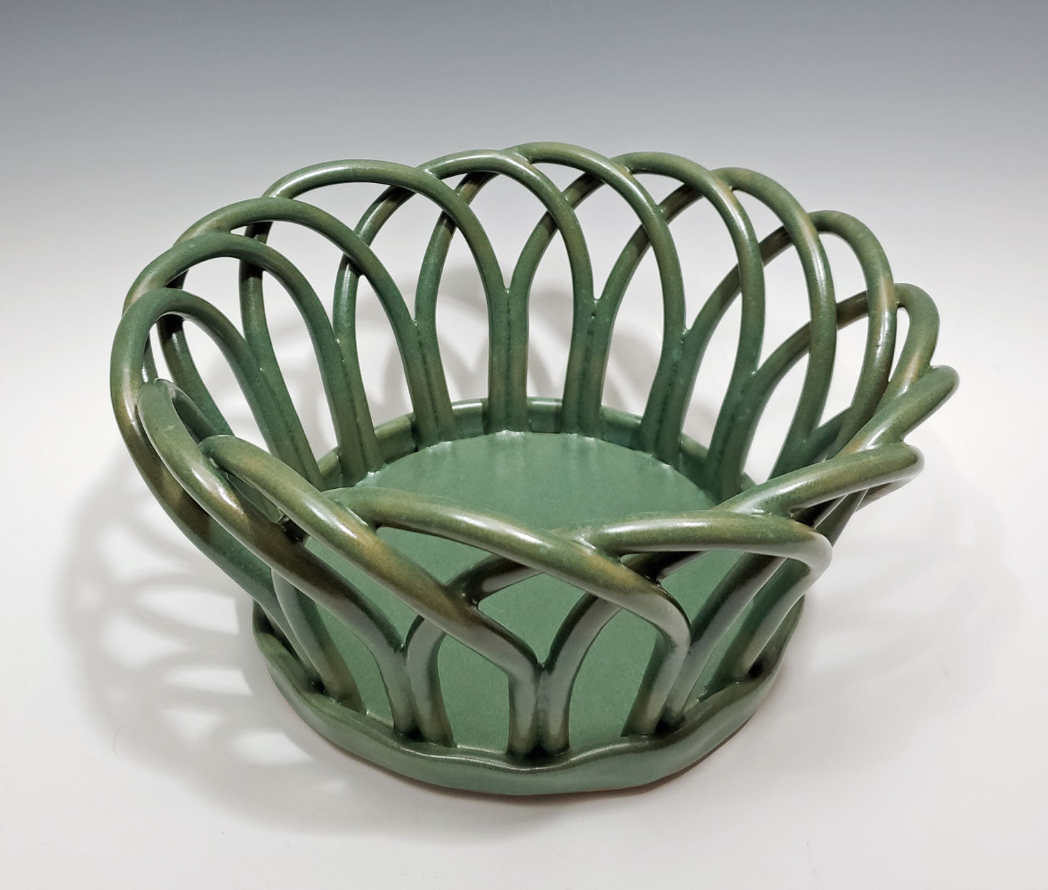 Green stoneware basket on a white background
