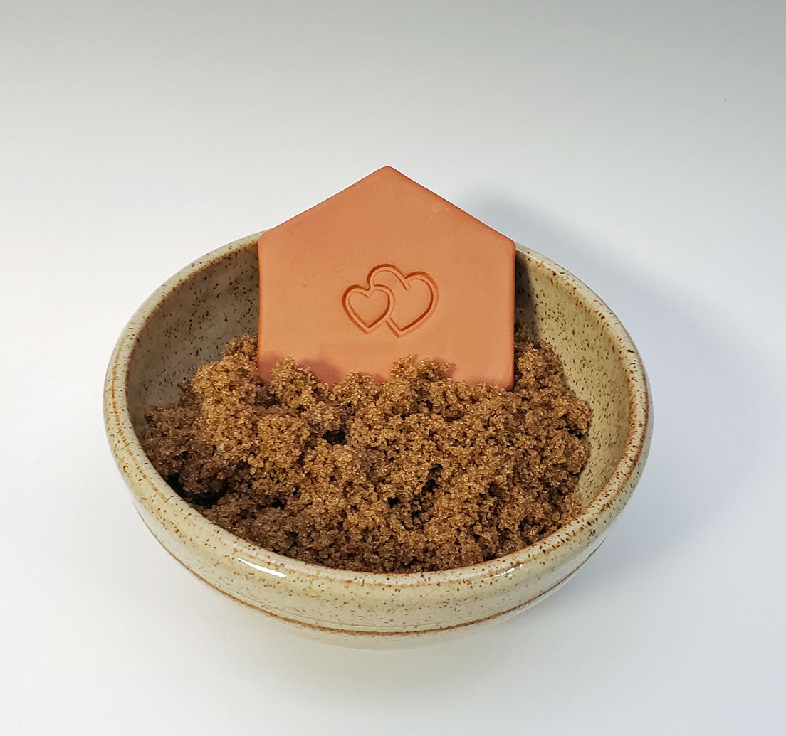 brown sugar keeper with heart design in a bowl of brown sugar