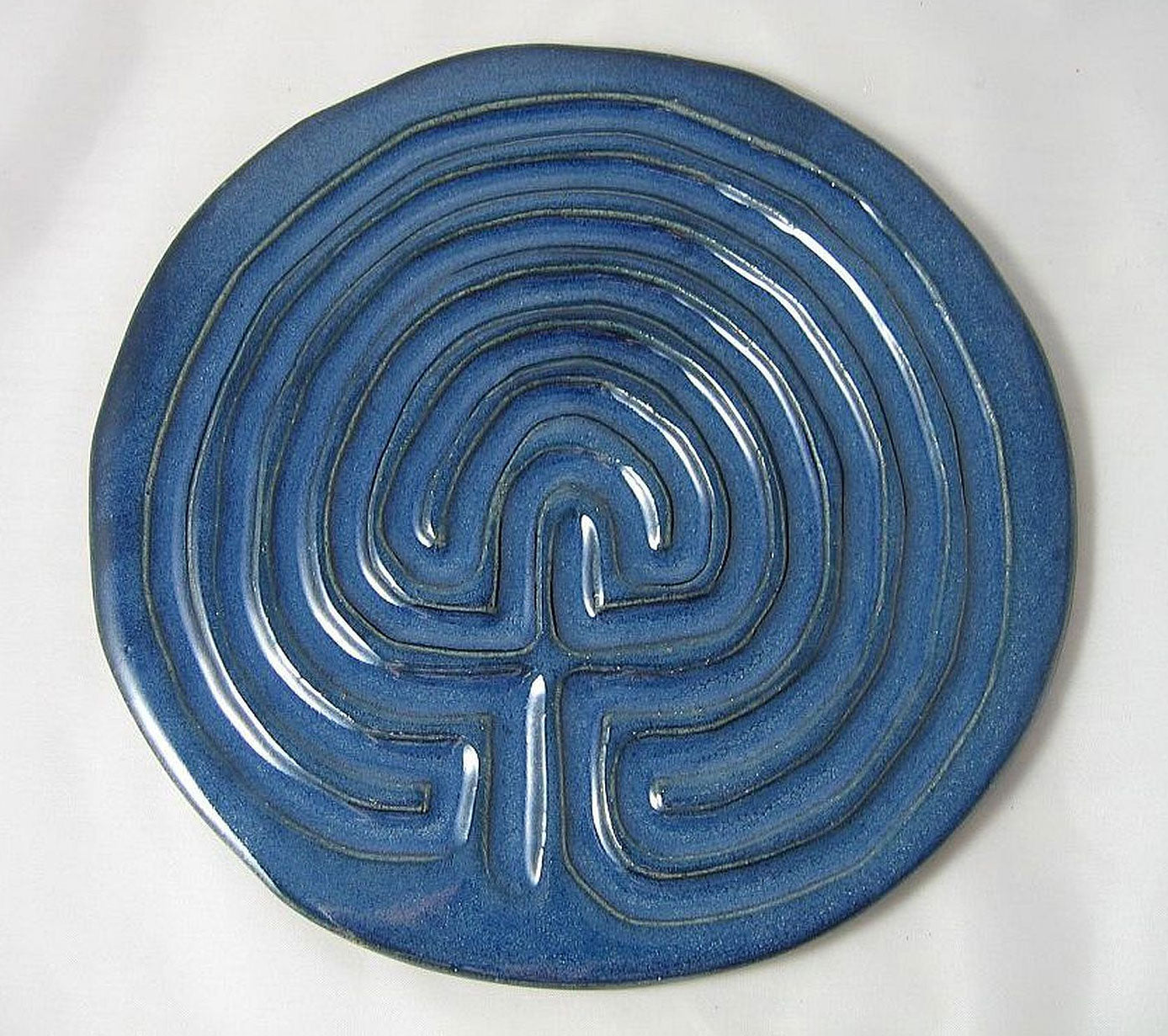 Dark blue ceramic Celtic finger labyrinth on a white background