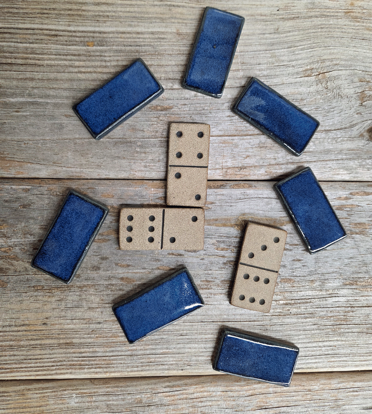Double-six domino set in dark blue glaze on a wood surface