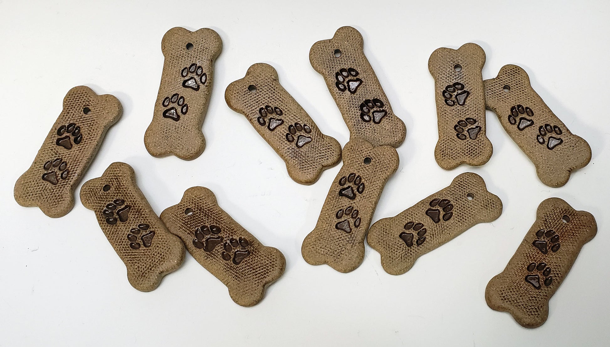Set of bone-shaped ornaments with paw prints on a white background