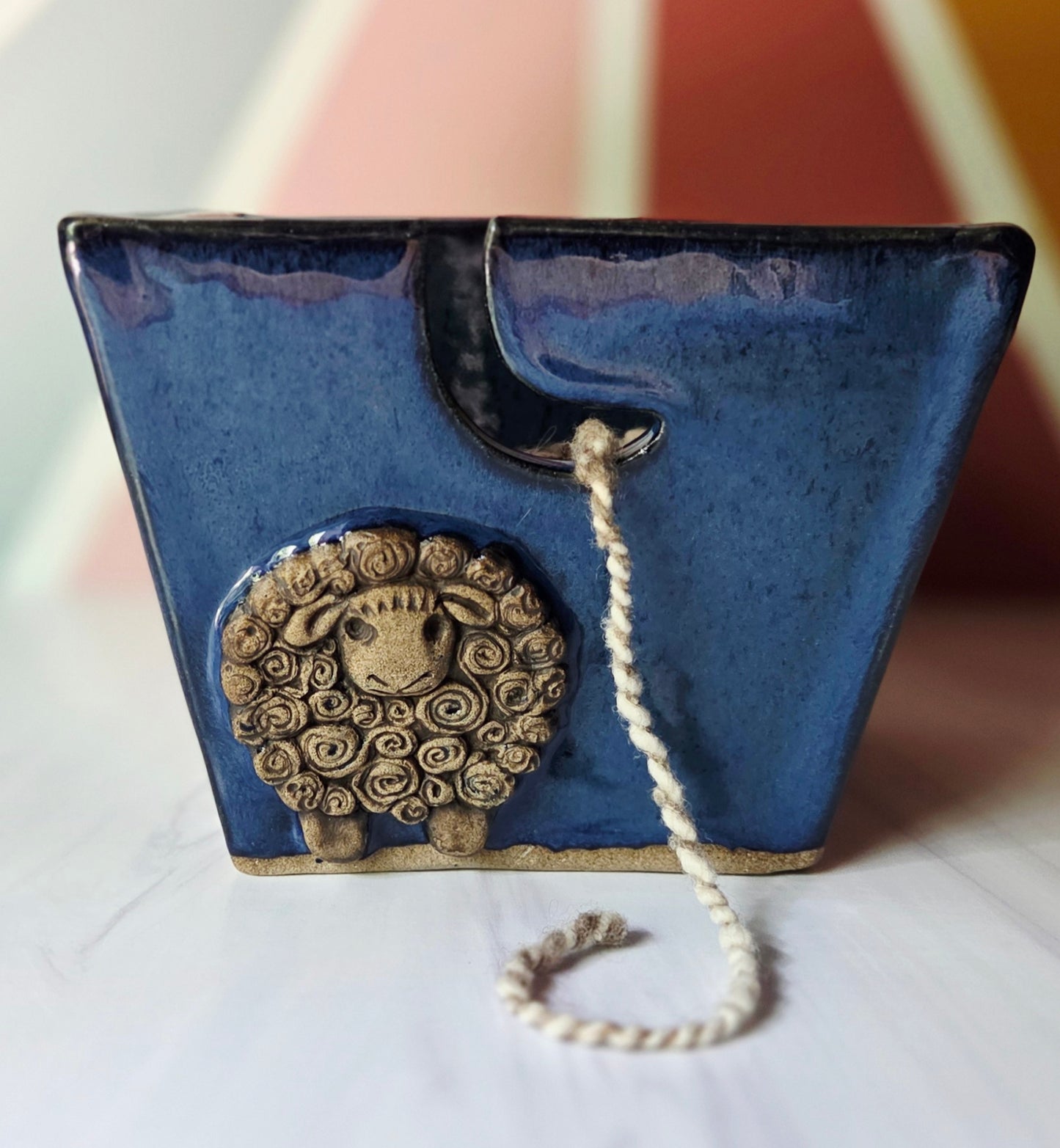 Dark blue stoneware yarn bowl with a decorative sheep design on a white background