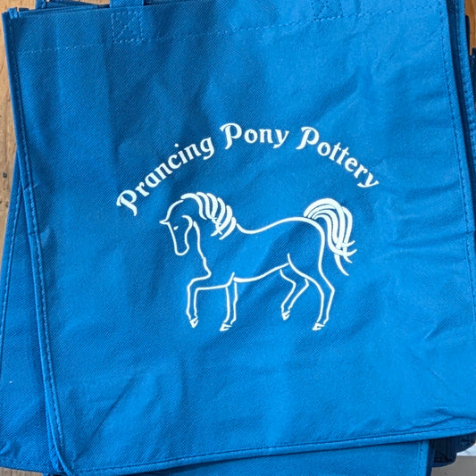 Blue tote bag with 'Prancing Pony Pottery' logo