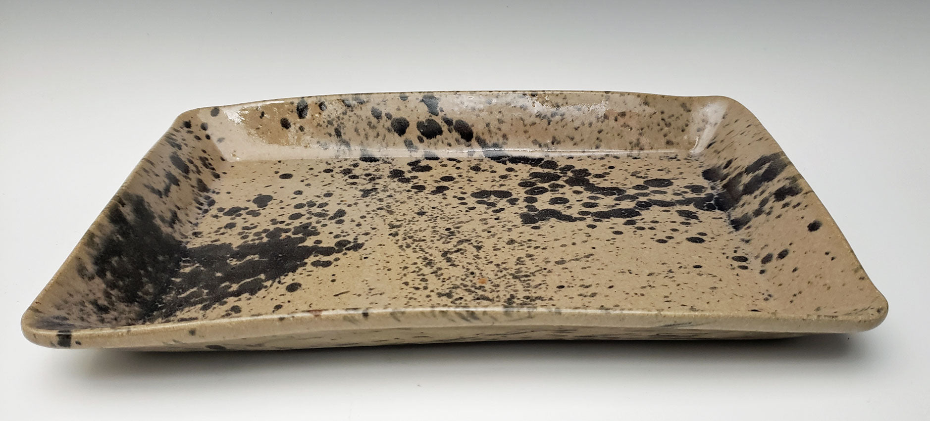 Rectangular stoneware serving platter with speckled design on a white background
