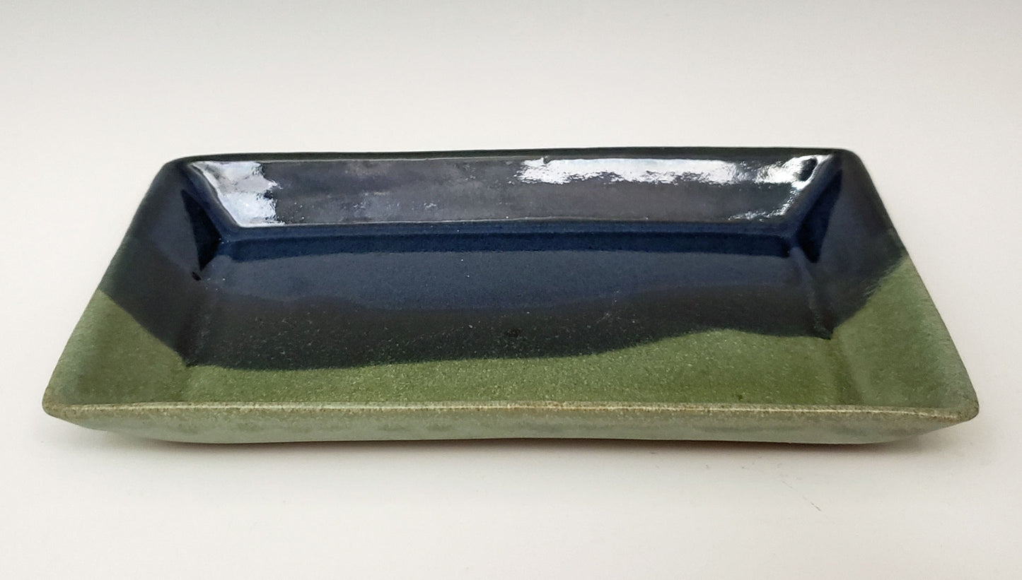 Rectangular stoneware side plate with dark blue & moss glaze on a white background