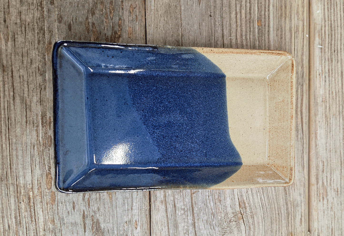 Rectangular side plate in a blue and eggshell glaze on a wood surface