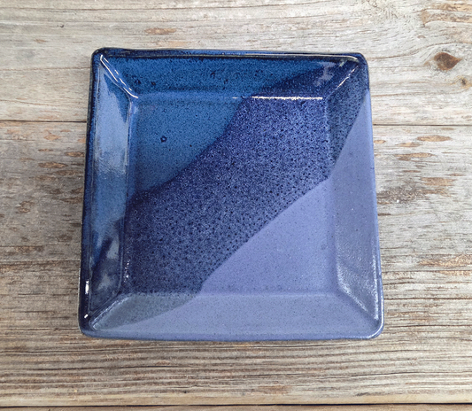 Blue and purple ceramic square dish on a wooden surface