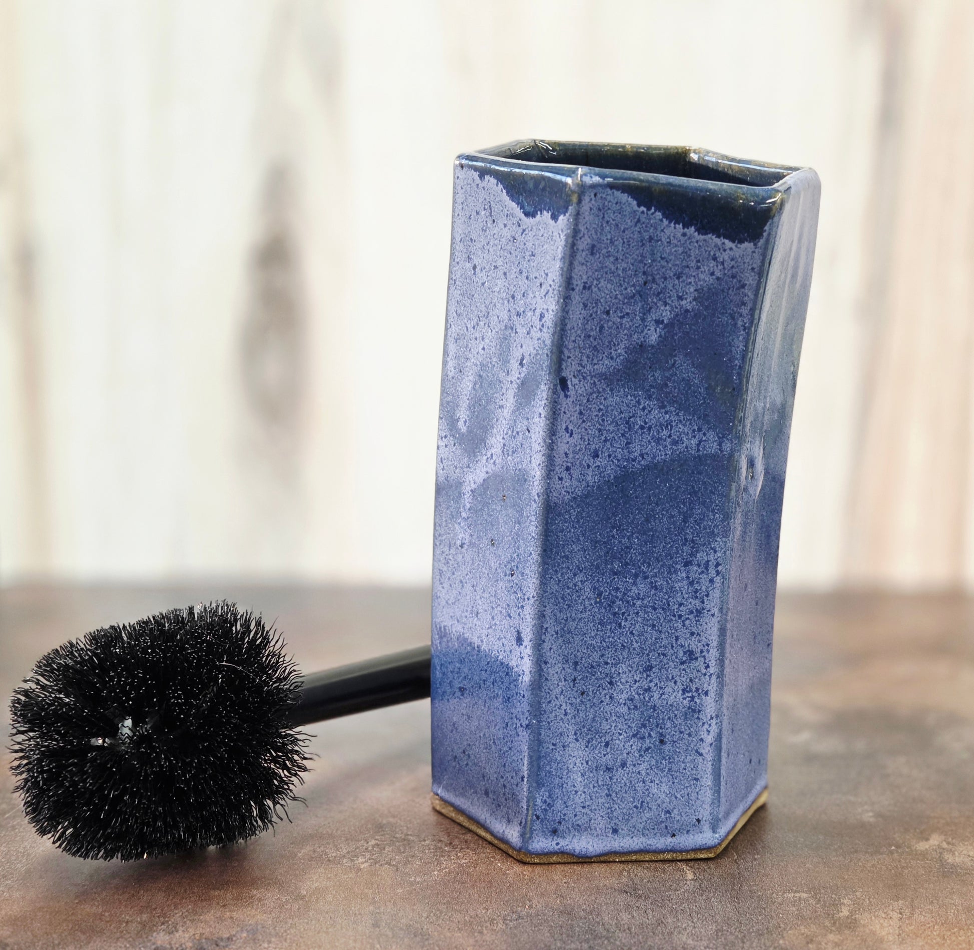 Purple ceramic toilet brush holder on a neutral background